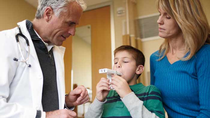 lekarz pomagający dziecku z produktem do leczenia astmy