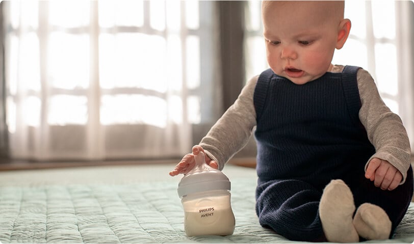 Dziecko szykujące się do karmienia z butelki.