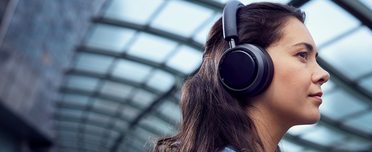 Kobieta słuchająca muzyki w podróży za pomocą słuchawek Philips L4