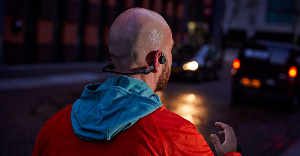 mężczyzna w słuchawkach z otwartymi uszami na zatłoczonej ulicy