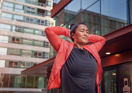 Kobieta korzystająca ze słuchawek bezprzewodowych Philips A5508 na zewnątrz