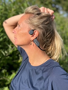 Kobieta korzystająca ze słuchawek sportowych Philips Bluetooth z przewodzeniem kostnym