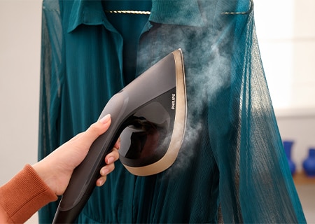 Technologia OptimalTemp chroniąca ubrania przed przegrzaniem i przypaleniem, wykorzystywana podczas prasowania bluzki z delikatnego materiału widzącej na wieszaku za pomocą systemu do prasowania Philips All-In-One Serii 8500.