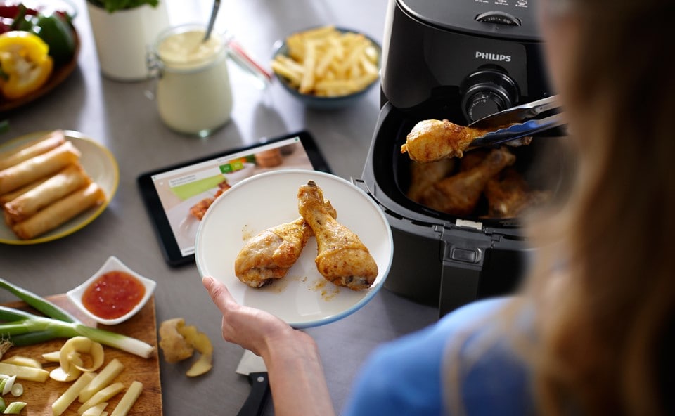 Kobieta przygotowująca kurczaka w Airfryer Philips Ovi Smart.