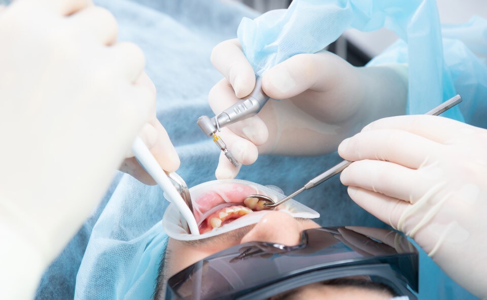 Pacjęt w gabinecie dentystycznym podczas zabiegu implantacji zęba.
