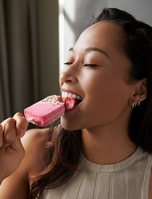 Kobieta zjadająca ze smakiem lody na patyku