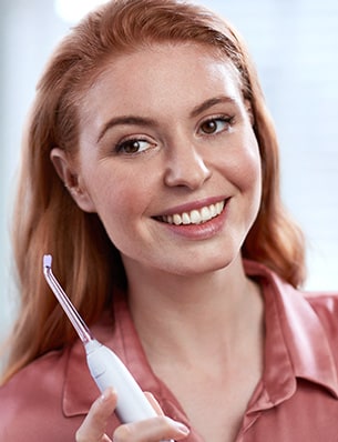 Kobieta trzymająca irygator do zębów Philips