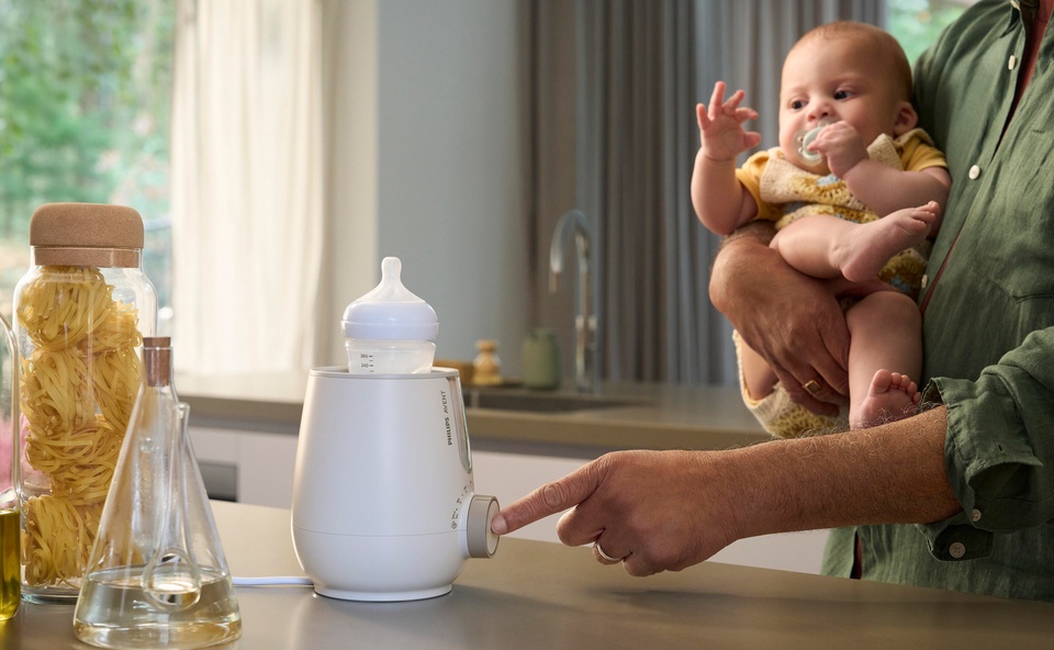 Tata używający podgrzewacza do butelek Philips Avent