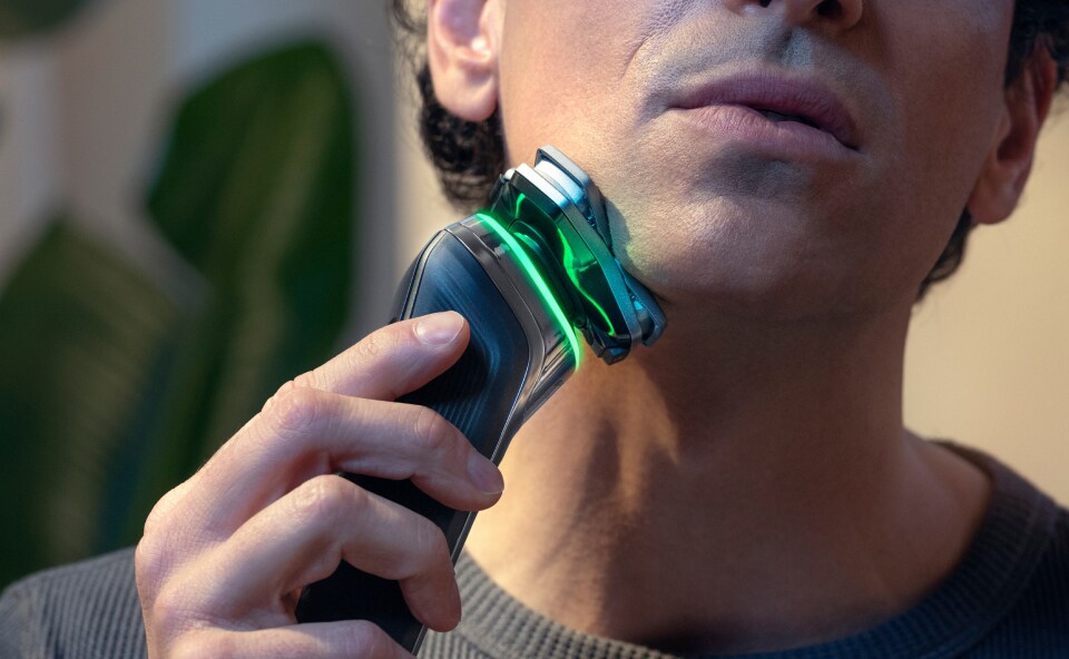 Mężczyzna goli brodę za pomocą Golarki Philips Seria S9000 Prestige