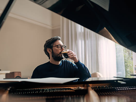 Pianista pijący kawę w trakcie komponowania nowego utworu