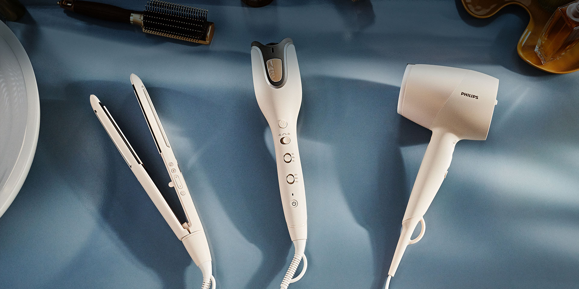 Pozostałe inteligentne produkty do pielęgnacji i stylizacji włosów z serii Philips SenseIQ: prostownica i suszarka.